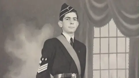 David Bishop Old image showing John in black uniform looking at camera. 