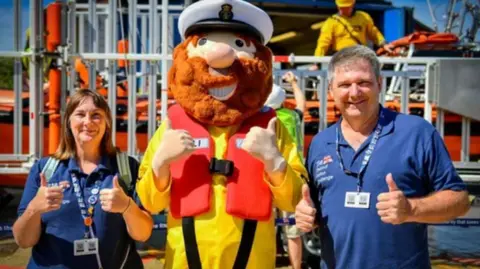 RNLI/Chris Bishop Allan and Helen Thornhill meet RNLI mascot Stormy Sam in Hunstanton