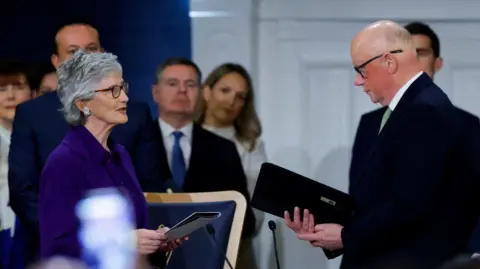 PA Catherine Connolly, with short grey hair, wearing a purple top and purple jacket, pictured during her inauguration ceremony as Ireland's 10th president in Dublin Castle. She is standing beside chief justice Donal O'Donnell (right).