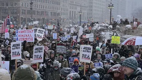 Getty Images Manifestanti si riuniscono in Michigan Avenue, a Chicago, durante una forte tempesta di neve per protestare contro l'immigrazione e le forze dell'ordine statunitensi.