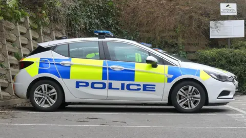Getty Images Police car with 'police' in blue font, viewed side on