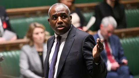 House of Commons UK Justice Secretary and Deputy Prime Minister David Lammy wearing a black suit and gestures with his hand while speaking in the House of Commons in London.