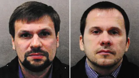 Metropolitan Police A side by side mugshot of Ruslan Boshirov (left) and Alexander Petrov (right). They are both wearing blue collared shirts and black jackets. Boshirov has dark hair and a goatee style beard. Petrov is shaven and has short dark hair.