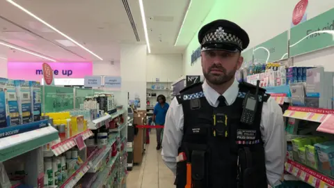 BBC police officer Darren watson standing in Boots