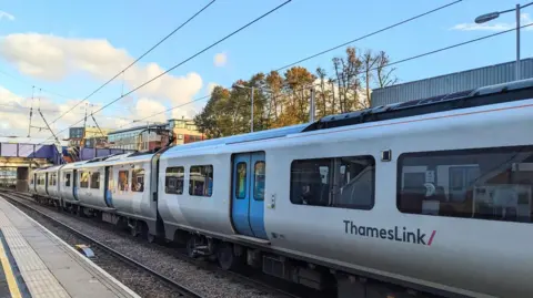 A Thameslink train is seen stationary at a train platform