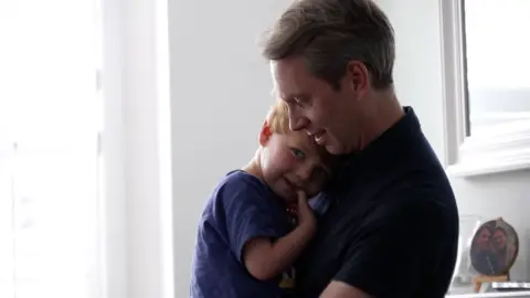 A dad hugs his child