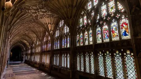 Getty Images The cloisters at Gloucester Cathedral, which have vaulted, Gothic vibe ceilings and colourful stained glass windows