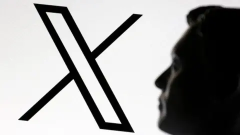 The silhouette of a man looking at the X logo on a bright white background