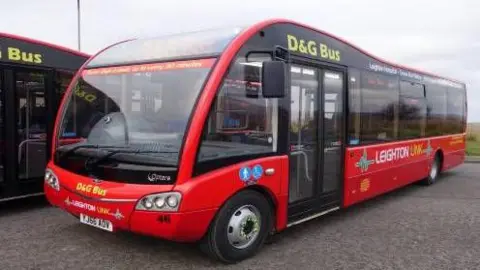 An empty red bus parked at a bus station