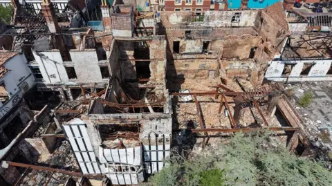 An aerial view of the old Raven Hotel in Droitwich - showing the roof blown off the building and piles of rubble on the floor.