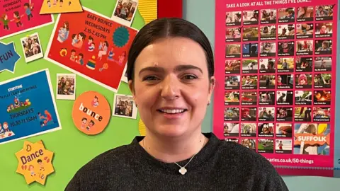 Jacob Ottaway/BBC Sophie Vendenbrink-Budgen smiles at the camera. She has dark hair that is slicked back behind her head. She wears a black jumper with a necklace around her neck.