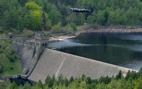 Getty Images A Lancaster bomber flies over Derwent Reservoir in Derbyshire, England on 16 May 2013, as part of events marking the 70th Anniversary of an air-raid on three dams in Germany's Ruhr Valley by a team of airmen dubbed the "Dambusters"