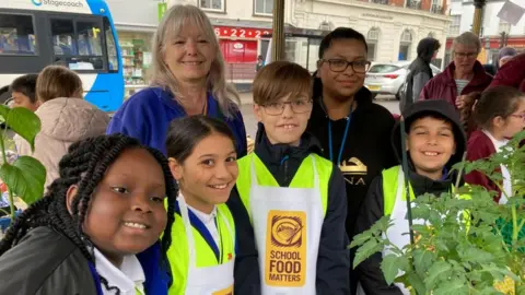 Alex Pope/BBC Pupils and teachers from Priory Primary School in Bedford selling items on Bedford Market