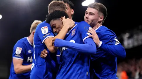 John Walton/PA Media Philogene is embraced by team mates after his hat-trick