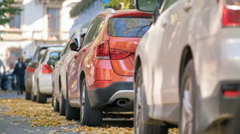 Getty Images/Bilanol Stock image of cars parked along a street