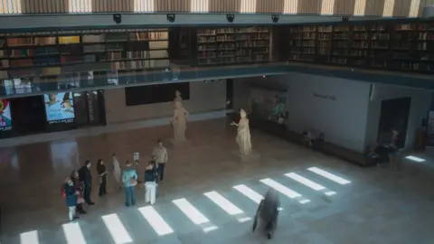 Wojtek Lubowiecki Looking down from above. The next floor is visible with shelves of library books.
