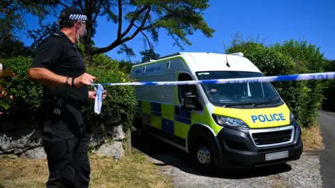 A police officer stands outside the house of Ann Widdecombe in Haytor on July 11, 2026 in Dartmoor, United Kingdom. 