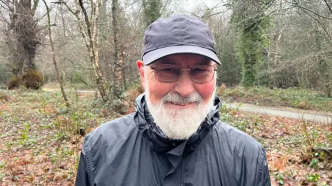 Former chair of The Friends of Tunbridge Wells and Rusthall Commons, John Barber standing in the rain on Tunbridge Wells Common