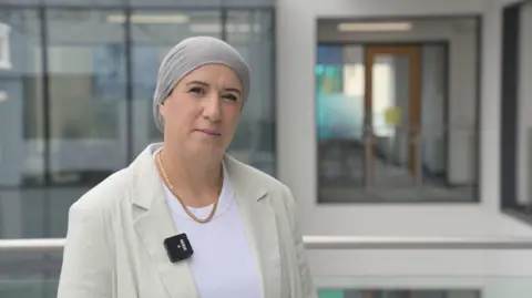 Wiltshire Council A lady wearing a pale blazer and a hijab on a balcony inside an office