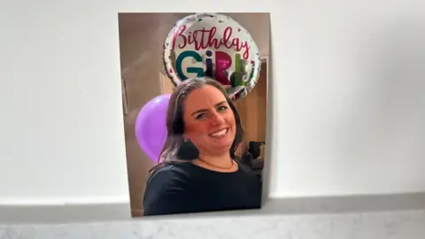 A woman with long hair and a birthday balloon