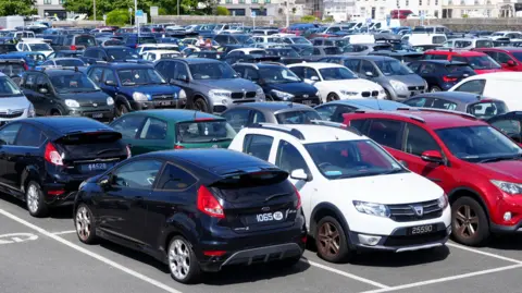 BBC Dozens of cars parked in a car park in Guernsey.
