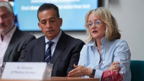 PA Media Sanjoy Kumar and Sinead O'Malley-Kumar at a press conference