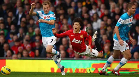 Richard Heathcote/Getty Images Footballer Ji Sung Park wearing red shirt appears to be flying as he falls following a challenge between Sunderland and Manchester United.