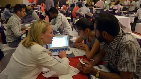 AFP via Getty Images Indian students listen to Director of Partnerships and Pathways at KPU International Anita Hamm (L) at a Canadian education fair in Amritsar on September 16, 2015.