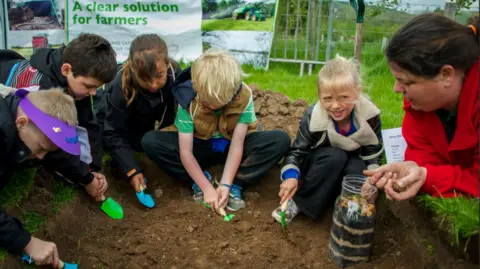 Glendale Agricultural Show  A group of children dig in the soil with trowels