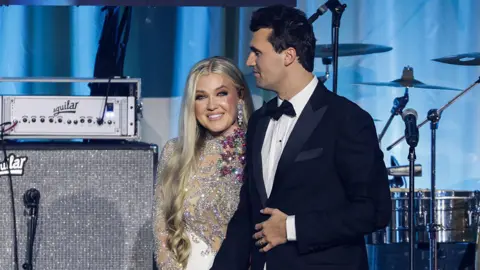 A imagem Getty Charlie Cort usava um taxido preto na frente de um coreto e sua esposa, Erica Lane Frantzov, que usava um vestido piscando, Turning Point USA Opening-E Ball.