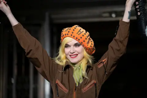 Getty Images Image of Pam Hogg with her hands up celebrating the end of a runway show