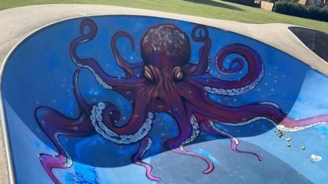 Large purple octopus on a blue background painted on a skate ramp in Spalding 