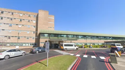 Google A general view of the Newcastle's Freeman Hospital. An ambulance is parked outside the main entrance, housed in a two-storey building with a glass front on the upper level. Next to it is a tall block with small windows. Taxis and other vehicles are parked outside.
