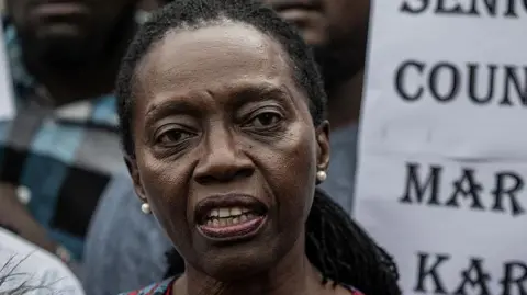 AFP via Getty Images Martha Karua speaks to journalists in Kenya after her deportation on 18 May 2025