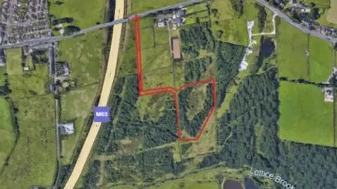 LDRS An aerial view of the site for the proposed Stanhill Road battery farm, showing fields to the right of the M65, with a road and piece of woodland edged in red