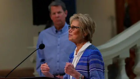 Georgia Department of Public Health Commissioner Dr. Kathleen Toomey stands in front of Governor Brian Kemp