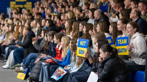 Team Bath A large crowd of netball fans, most of them female, are seen packed into terraced seating as they watch Team Bath take on Nottingham Forest