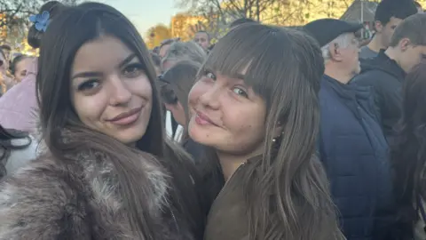 Two young women in a crowd