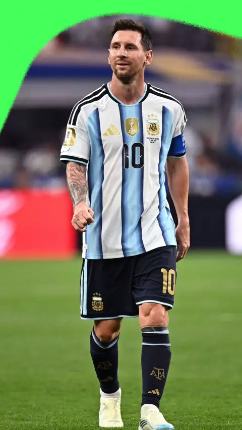Lionel Messi walking across a pitch in full Argentina football kit