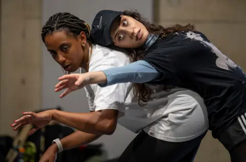 Two actresses, one leaning on the back of the other, rehearse for Romeo and Juliet at Bristol Old Vic