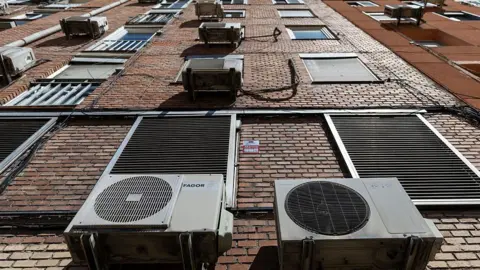 Outdoor air conditioning units are pictured on a building