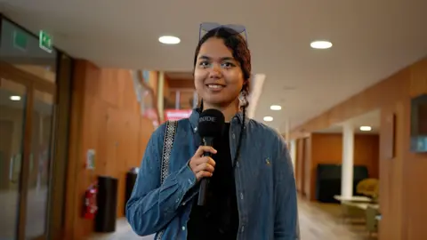 University of Kent Noor Aliya Khan holding a microphone