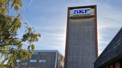 Justin Langdon SKF Factory. Its shows a talk concrete building with SKF written at the top in blue letters 