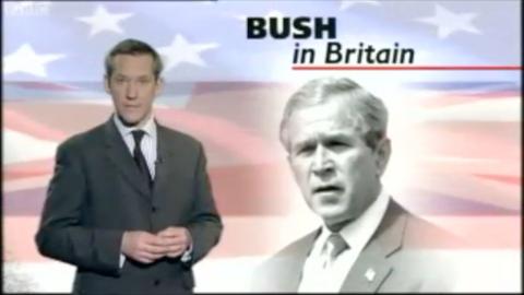 BBC News reporter James Westhead standing on the left looking down the lens.  Behind him a graphic with George W Bush in front of a stars and stripes flag and the text 'BUSH IN BRITAIN'.