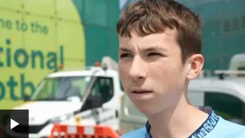 A teenager wearing a Manchester City shirt is pictured during an interview with the BBC
