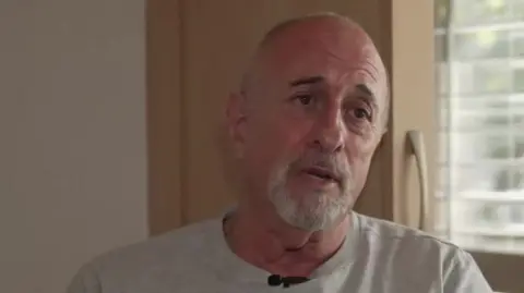 Richard Manville wearing a grey t-shirt