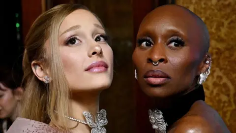 Reuters Ariana Grande and Cynthia Erivo facing each   different   and some  looking sideways successful  the aforesaid  direction, wearing jewelled necklaces and earrings astatine  the Australian premiere of Wicked successful  November.