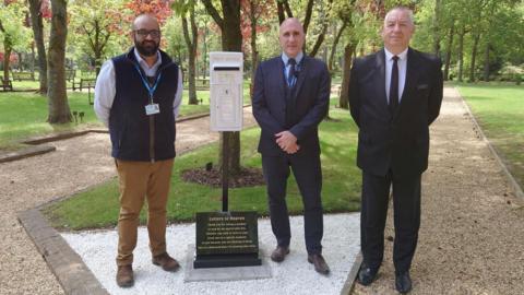 Councillor Bal Anota, Chris Black - the council's cemeteries and crematorium manager and Peter Childerley  - the council's cemeteries and crematorium assistant manager standing by the white box