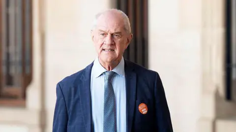 Roelf Meyer is seen in a blue suit and tie as he stands outside the Union Buildings