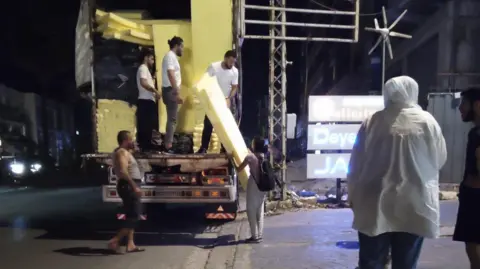 Hania overseeing a delivery of mattresses in Sidon. 